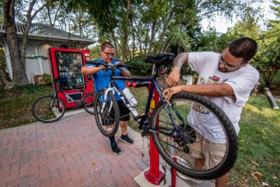 Two men work on a bike at the Fixit Station in Crystal City